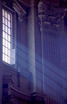 Lichtstralen vallen door het raam in de kerk.
